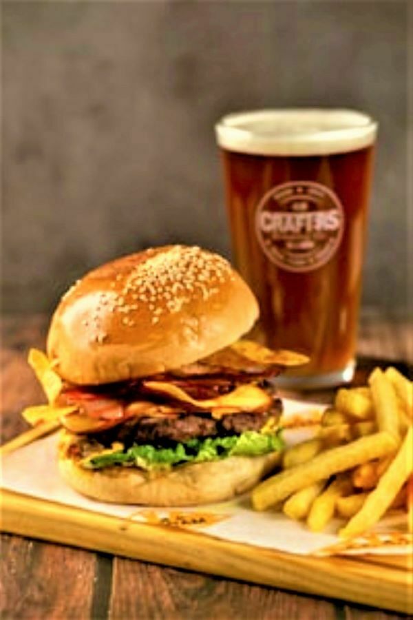 Cheese burger, french fries and a glass of beer on a table