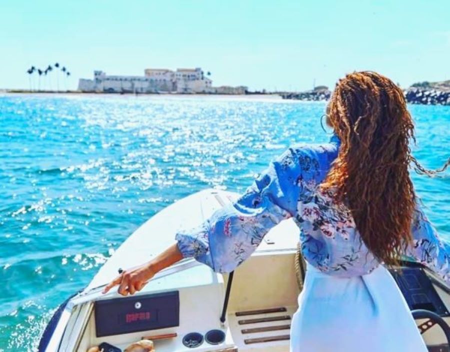 A lady in a boat ride towards the Cape Coast Castle.