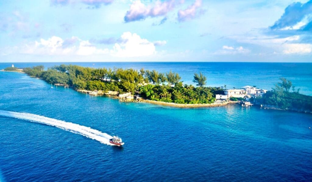 The Ultimate Haven Paradise Island aerial view with a boat streaming by it.