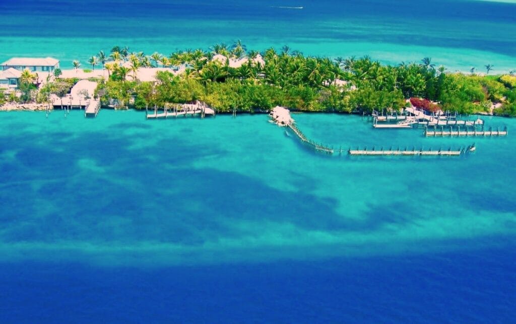 An aerial view of THEBI ISLAND, where The Ultimate Haven is located with a bluish ocean around it.